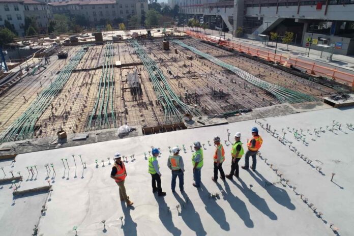 men in high-vis vests overlooking large construction site