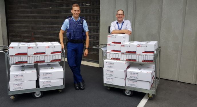 policeman and charity worker standing with collection of family food boxes in Christchurch. policeman and charity worker standing with collection of family food boxes in Christchurch.