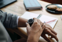 Time-Saving Life Hacks to Live Your Best Life woman is looking at her watch with journal on desk in background